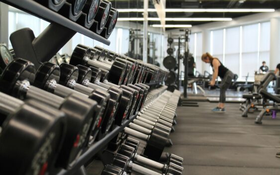 woman standing surrounded by exercise equipment